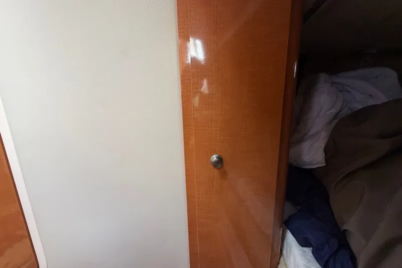 Slide: The Image of Wooden cabin door inside 2008 Chaparral Signature 290 boat, partially open with visible bedding. - 93