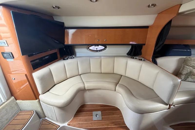 Slide: The Image of 2008 Chaparral Signature 290 interior with curved seating, wood accents, and mounted TV. - 49