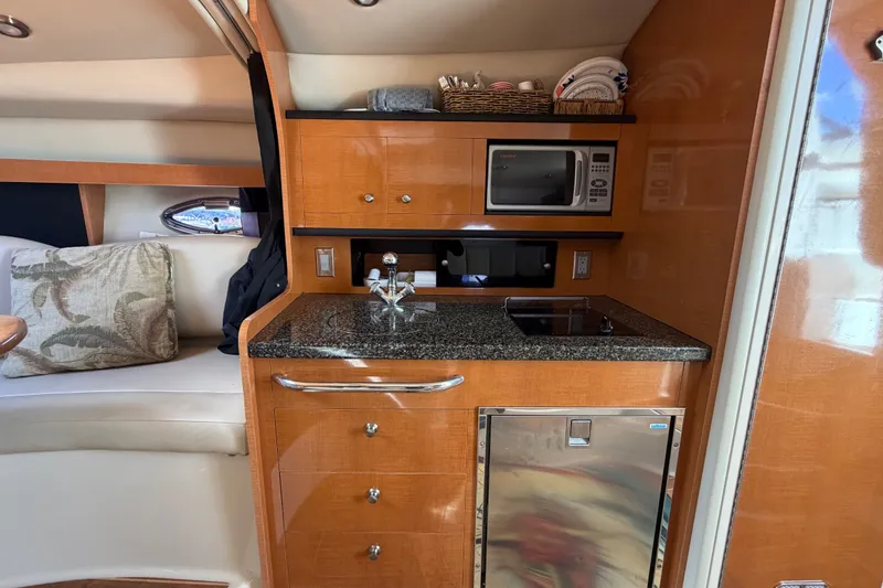 Slide: The Image of 2008 Chaparral Signature 290 interior with kitchenette, featuring microwave, sink, and compact fridge. - 71