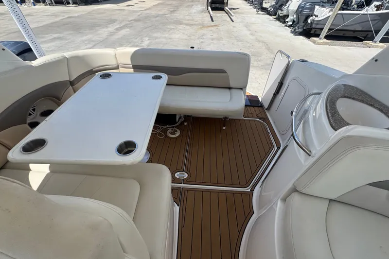 Slide: The Image of 2008 Chaparral Signature 290 boat interior with seating and table on teak flooring. - 50