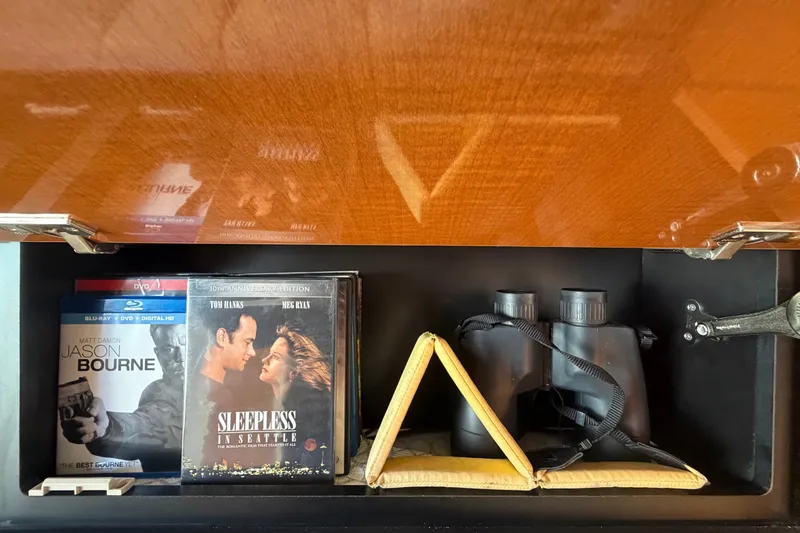 Slide: The Image of DVDs and binoculars in a Chaparral Signature 290 boat storage compartment. - 54