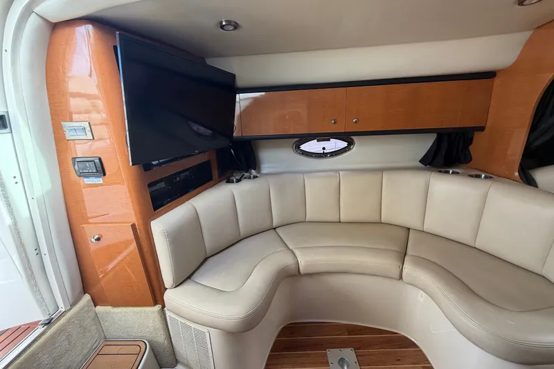 Slide: The Image of 2008 Chaparral Signature 290 interior with curved seating, wood accents, and mounted TV. - 46