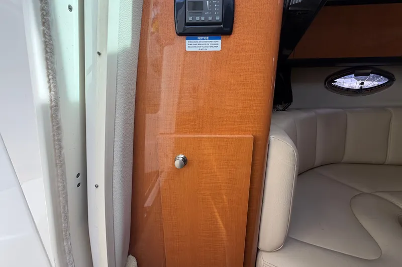 Slide: The Image of Interior of 2008 Chaparral Signature 290 boat, featuring wood paneling and beige seating. - 47