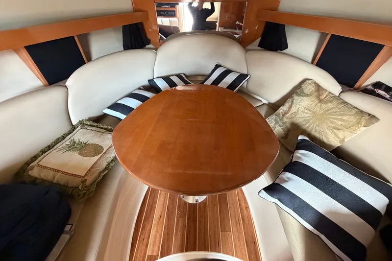 Slide: The Image of 2008 Chaparral Signature 290 cabin with wooden table and striped cushions. - 26