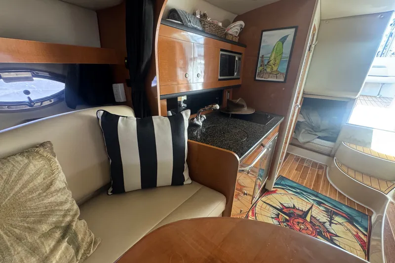 Slide: The Image of 2008 Chaparral Signature 290 interior with kitchenette, seating, and nautical decor. - 28