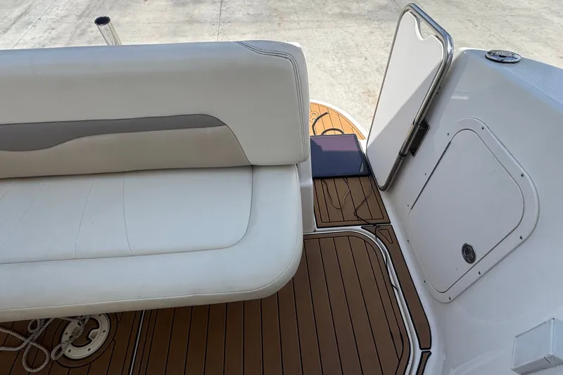 Slide: The Image of 2008 Chaparral Signature 290 boat interior with white seating and teak flooring. - 54