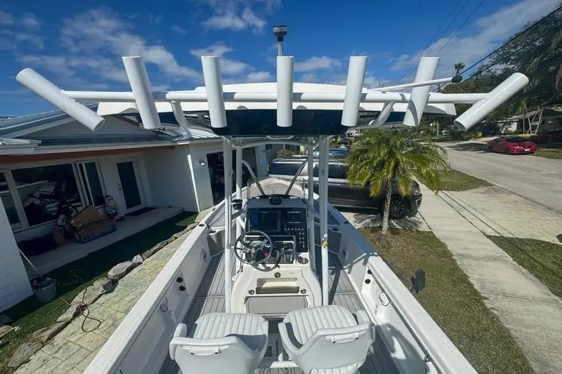 Slide: The Image of 2018 Blue Wave 2400 PureBay boat with rod holders, parked in a residential driveway. - 14