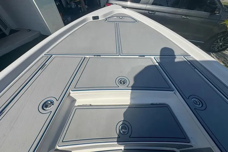 Slide: The Image of 2018 Blue Wave 2400 PureBay boat deck with storage compartments and shadow. - 24