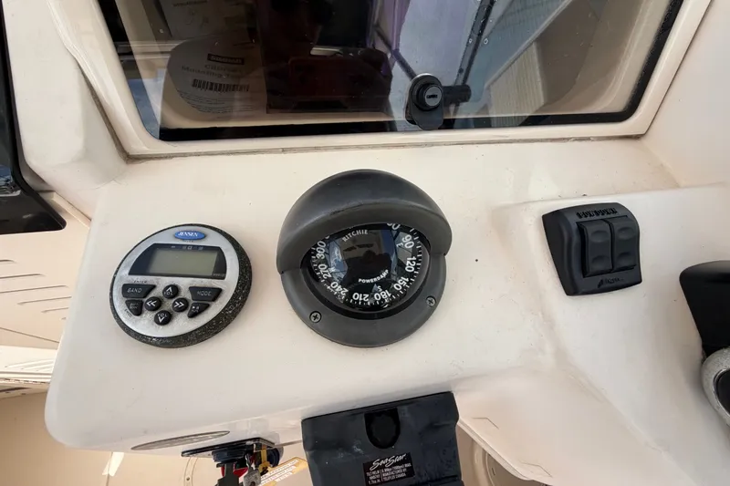 Slide: The Image of 2008 Grady-White Seafarer 226 dashboard with compass and control panel. - 35