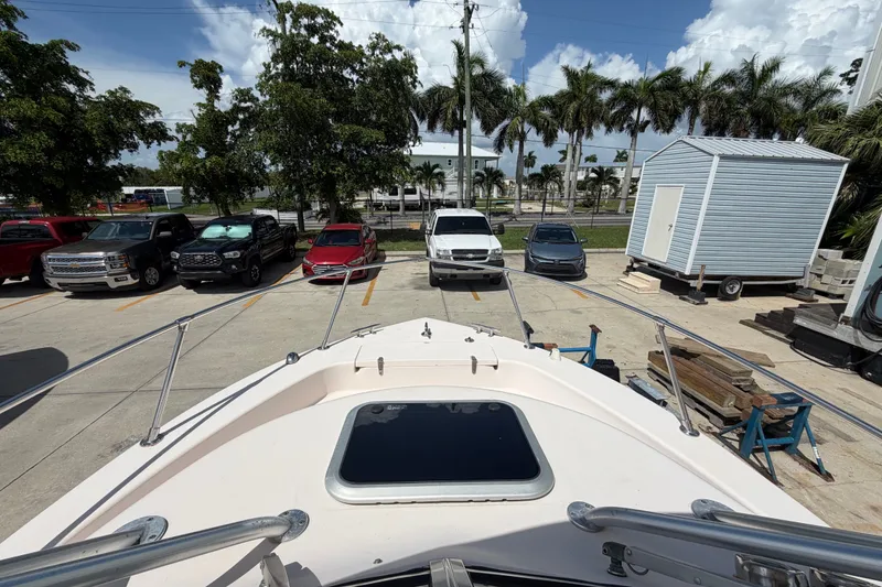 Slide: The Image of 2008 Grady-White Seafarer 226 boat parked, surrounded by vehicles and palm trees. - 16