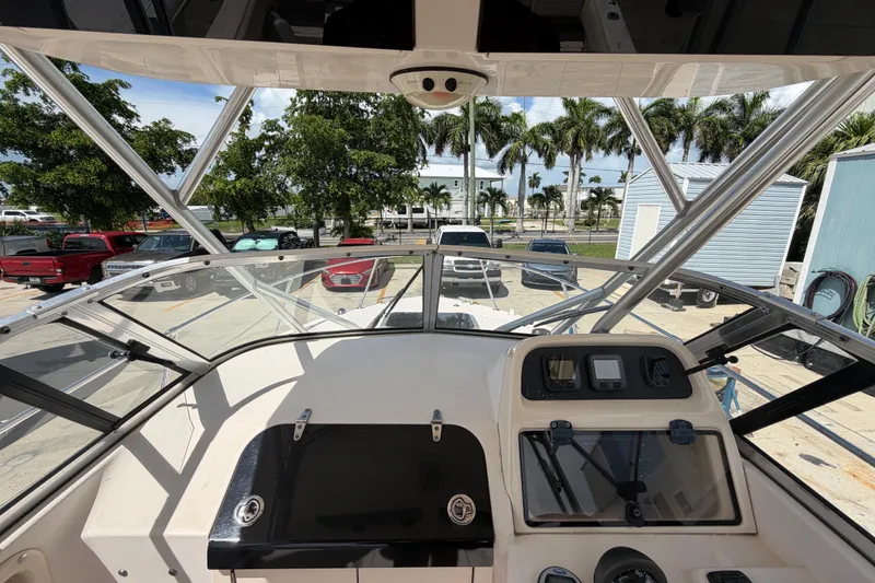 Slide: The Image of 2008 Grady-White Seafarer 226 boat dashboard with marina view and parked vehicles. - 20