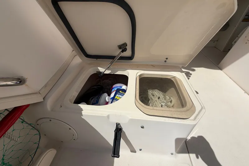 Slide: The Image of Open storage compartment on 2008 Grady-White Seafarer 226 boat, containing ropes and cleaning supplies. - 54