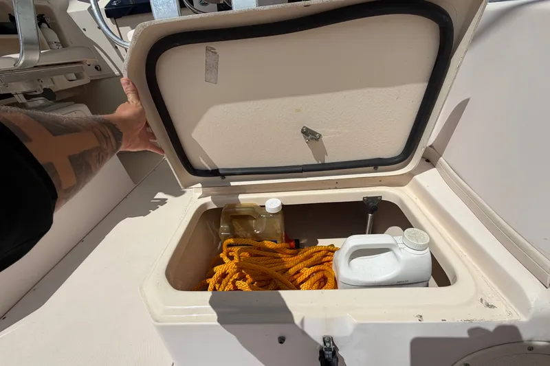 Slide: The Image of Storage compartment on a 2008 Grady-White Seafarer 226 boat with rope and containers. - 52