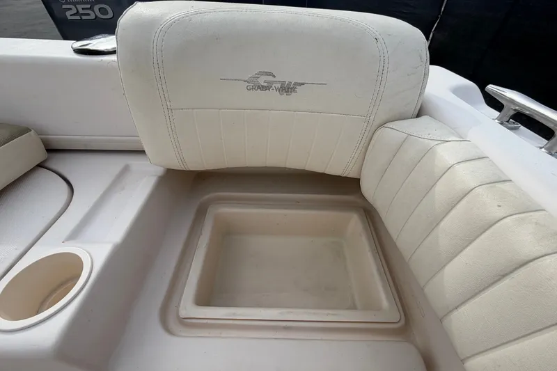 Slide: The Image of Grady-White Seafarer 228 boat interior, featuring white cushioned seating and storage compartment. - 81