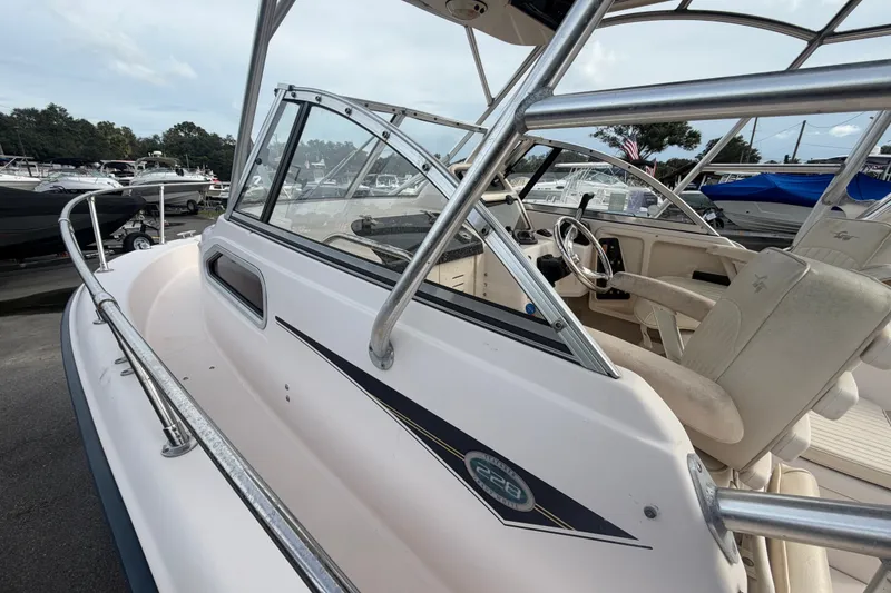 Slide: The Image of 2008 Grady-White Seafarer 228 boat interior with steering wheel and seating, docked at marina. - 54
