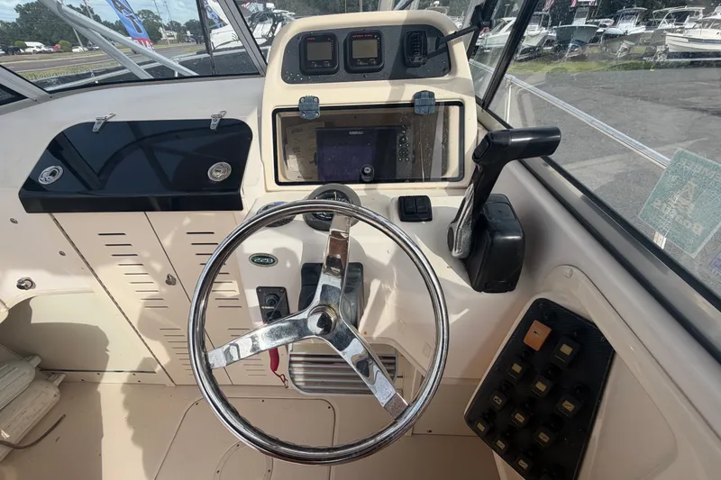 Slide: The Image of 2008 Grady-White Seafarer 228 boat helm with steering wheel and control panel. - 36