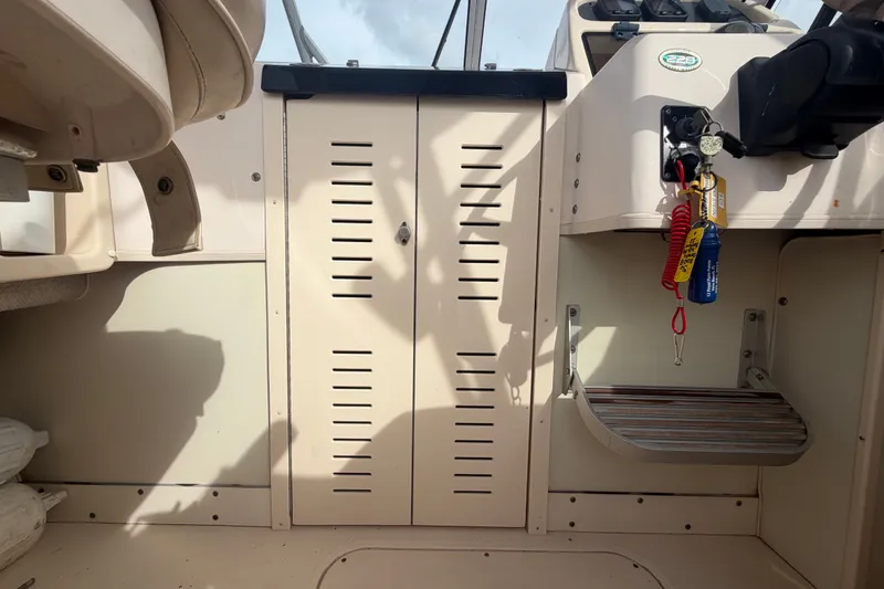 Slide: The Image of Interior view of a 2008 Grady-White Seafarer 228 boat, featuring storage and control panel. - 44