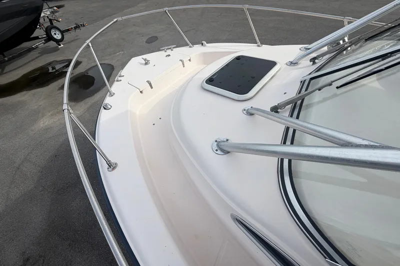 Slide: The Image of 2008 Grady-White Seafarer 228 boat deck with railing and hatch, parked on pavement. - 55
