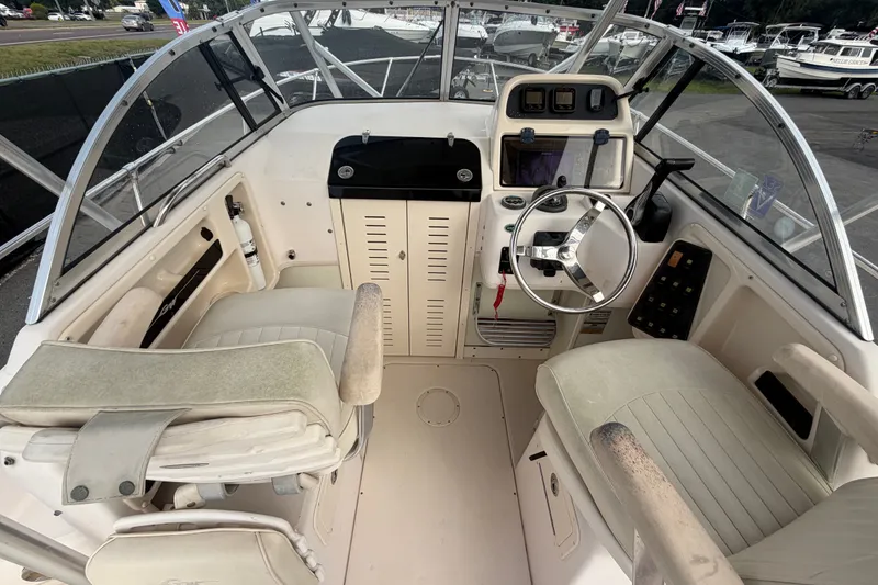 Slide: The Image of 2008 Grady-White Seafarer 228 boat cockpit with steering wheel and control panel. - 23