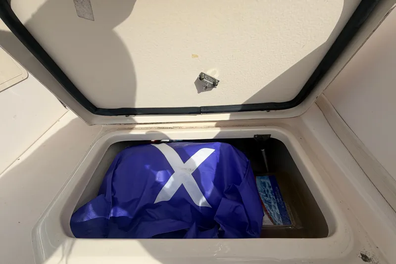 Slide: The Image of Storage compartment of 2008 Grady-White Seafarer 228 with blue flag inside. - 21