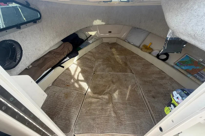 Slide: The Image of 2008 Grady-White Seafarer 228 cabin interior with carpet, fan, and storage items. - 46
