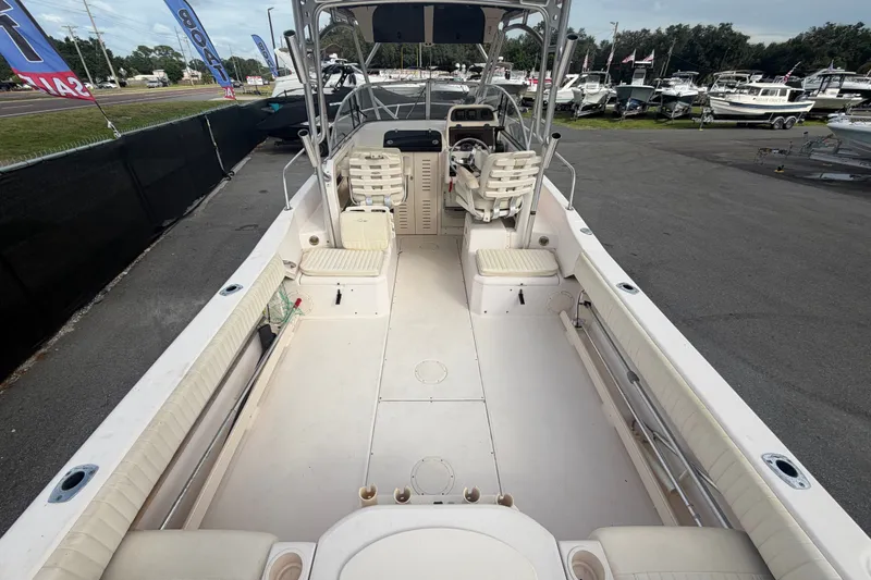 Slide: The Image of 2008 Grady-White Seafarer 228 boat interior, spacious deck, and seating area at a marina. - 13