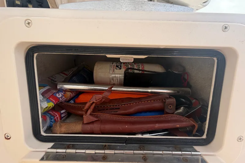Slide: The Image of Storage compartment on a 2008 Grady-White Seafarer 228 boat with tools and supplies. - 27
