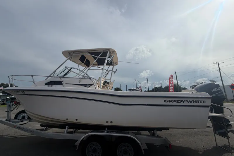 Slide: The Image of 2008 Grady-White Seafarer 228 boat on trailer, side view under cloudy sky. - 8