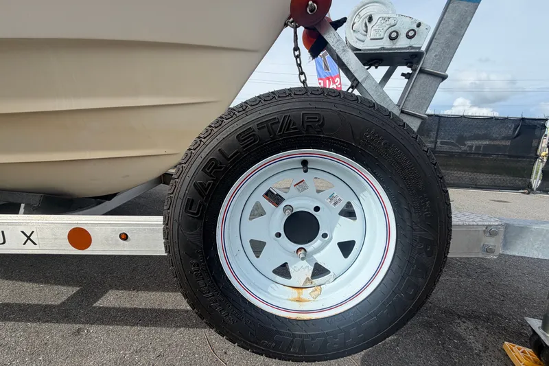 Slide: The Image of Trailer tire of a 2008 Grady-White Seafarer 228 boat on a metal frame. - 90