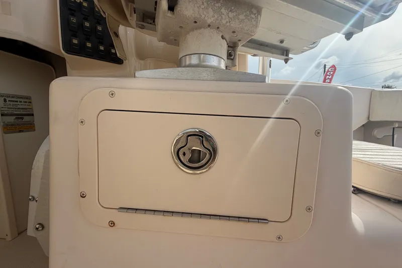 Slide: The Image of 2008 Grady-White Seafarer 228 boat compartment with latch, sunlight reflecting on surface. - 26