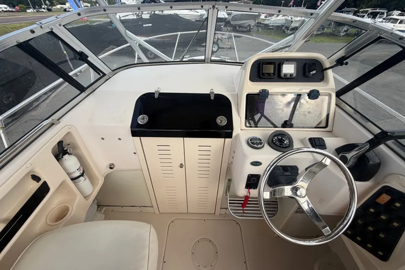 Slide: The Image of 2008 Grady-White Seafarer 228 boat cockpit with steering wheel and control panel. - 24