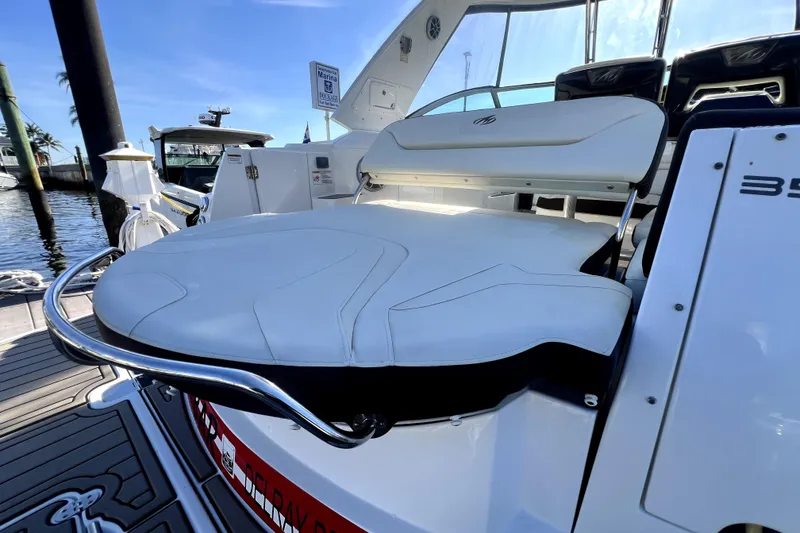 Slide: The Image of 2018 Monterey 355 Sport Yacht with sleek white seating and polished metal accents at a marina. - 33