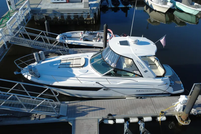 Slide: The Image of 2018 Monterey 355 Sport Yacht docked at marina, sleek design, white exterior, American flag displayed. - 15