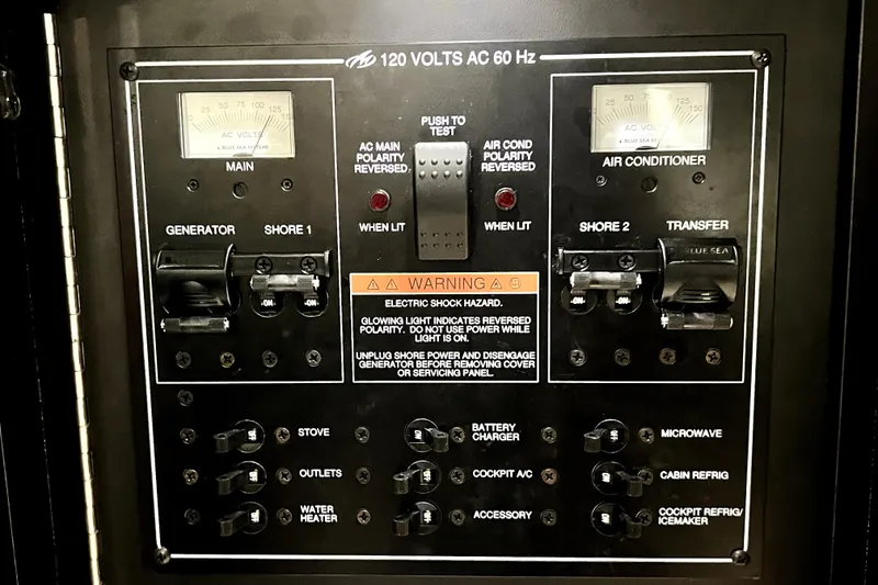 Slide: The Image of Electrical control panel of a 2018 Monterey 355 Sport Yacht, featuring various switches and meters. - 76