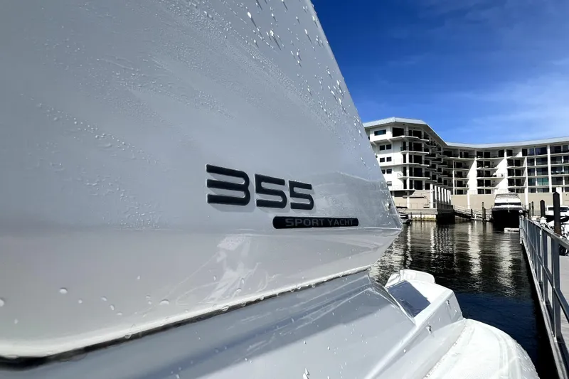 Slide: The Image of 2018 Monterey 355 Sport Yacht docked at a marina with modern buildings in the background. - 25