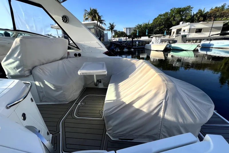 Slide: The Image of 2018 Monterey 355 Sport Yacht interior with covered seating and table, docked by the water. - 35