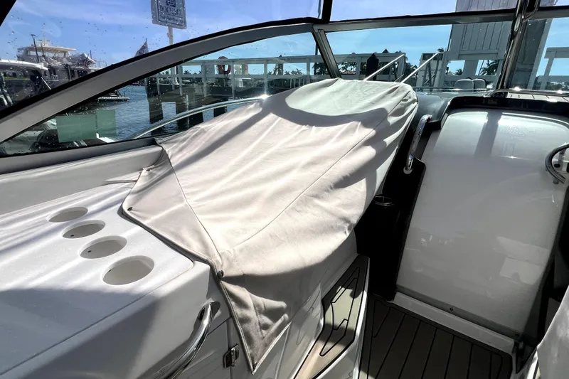 Slide: The Image of 2018 Monterey 355 Sport Yacht interior with covered seating and cup holders, dockside view. - 42