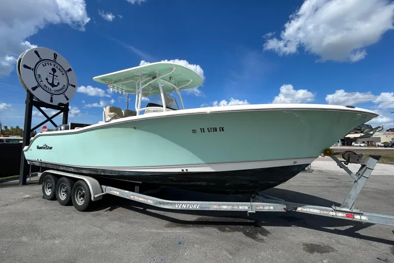 Slide: The Image of 2018 NauticStar 28 XS boat on trailer under blue sky. - 0