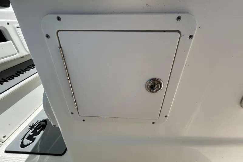 Slide: The Image of 2018 NauticStar 28 XS boat storage compartment with lock, featuring sleek white design. - 67