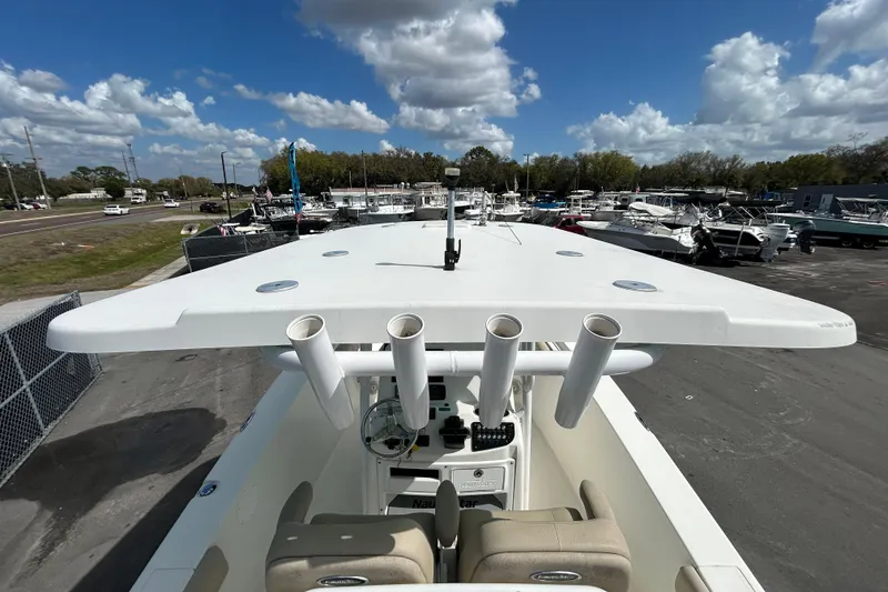 Slide: The Image of 2018 NauticStar 28 XS boat with rod holders, parked under a cloudy sky. - 16