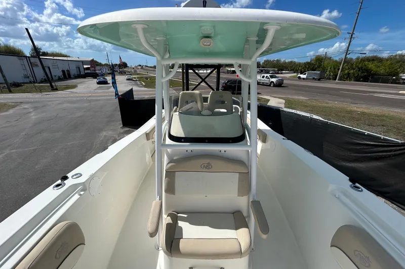 Slide: The Image of 2018 NauticStar 28 XS boat interior with seating and console, parked outdoors. - 34