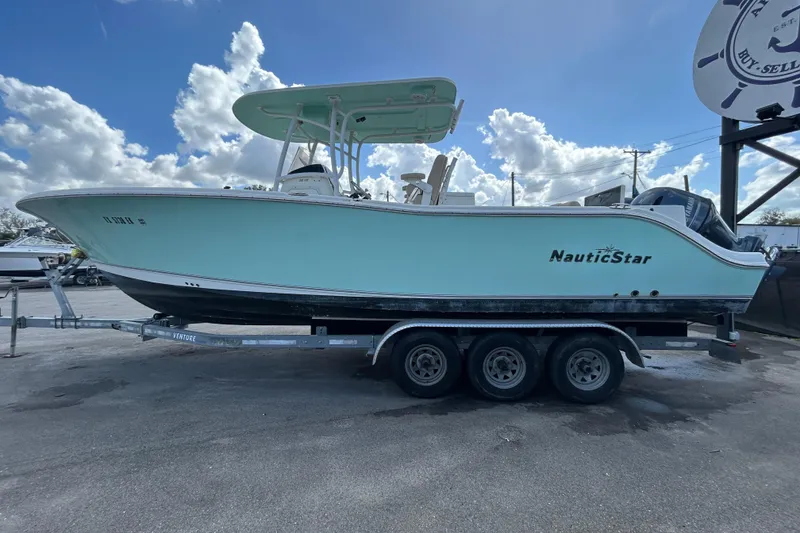 Slide: The Image of 2018 NauticStar 28 XS boat on trailer under a partly cloudy sky. - 4