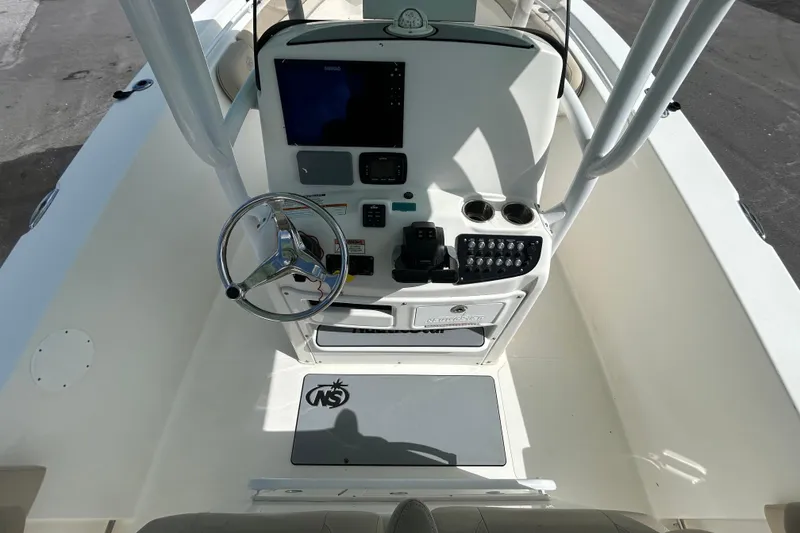 Slide: The Image of 2018 NauticStar 28 XS boat console with steering wheel and navigation controls. - 19