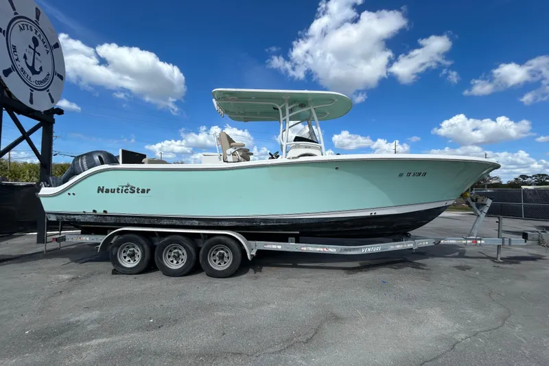 Slide: The Image of 2018 NauticStar 28 XS boat on trailer under blue sky with clouds. - 1