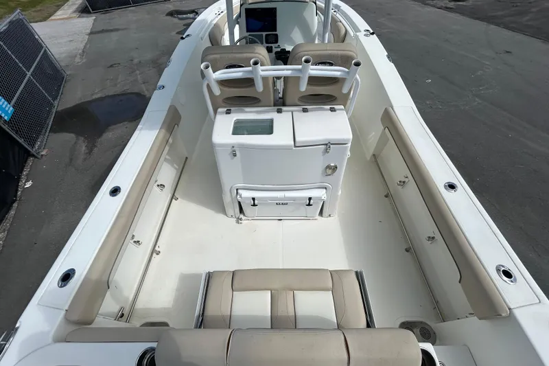 Slide: The Image of 2018 NauticStar 28 XS boat interior with seating and console, docked on pavement. - 12