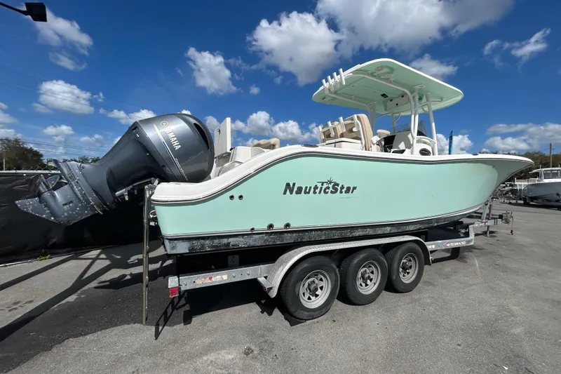 Slide: The Image of 2018 NauticStar 28 XS boat on trailer with Yamaha engine under blue sky. - 2
