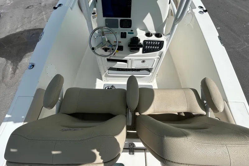Slide: The Image of 2018 NauticStar 28 XS boat interior with steering wheel and beige seating. - 17