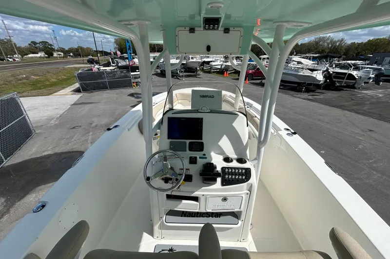 Slide: The Image of 2018 NauticStar 28 XS boat cockpit with steering wheel and control panel. - 18