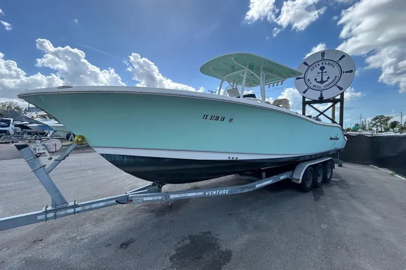 Slide: The Image of 2018 NauticStar 28 XS boat on trailer under a partly cloudy sky. - 5