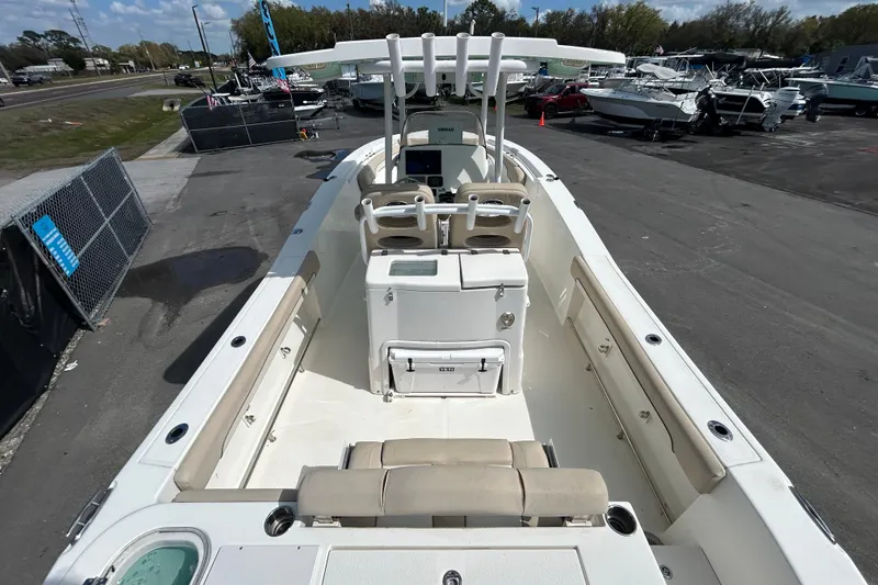 Slide: The Image of 2018 NauticStar 28 XS boat with spacious deck and seating, parked in a marina. - 11
